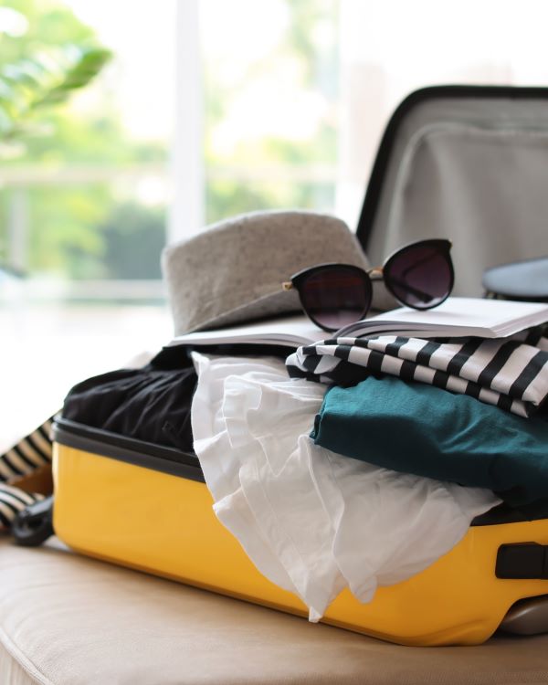 An open suitcase filled with clothes and accessories