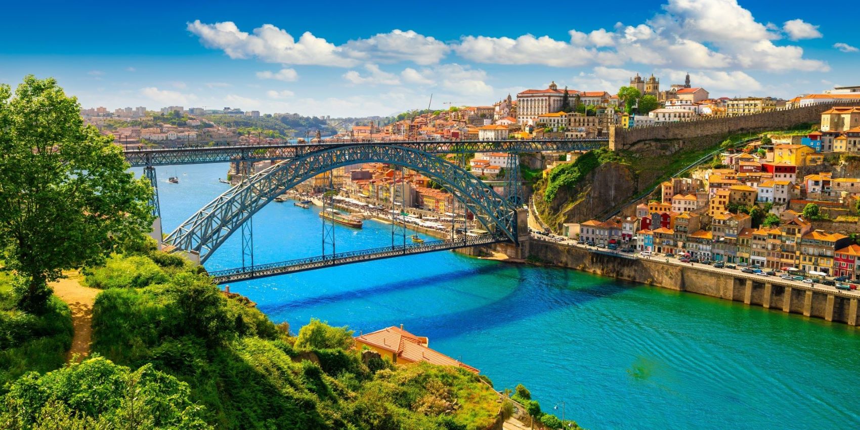 aerial view of bridge through riverside village over blue water