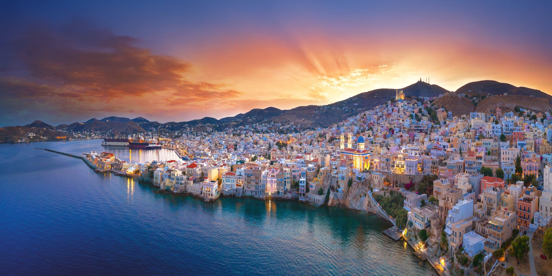 aerial view of seaside town with small boats at sunset