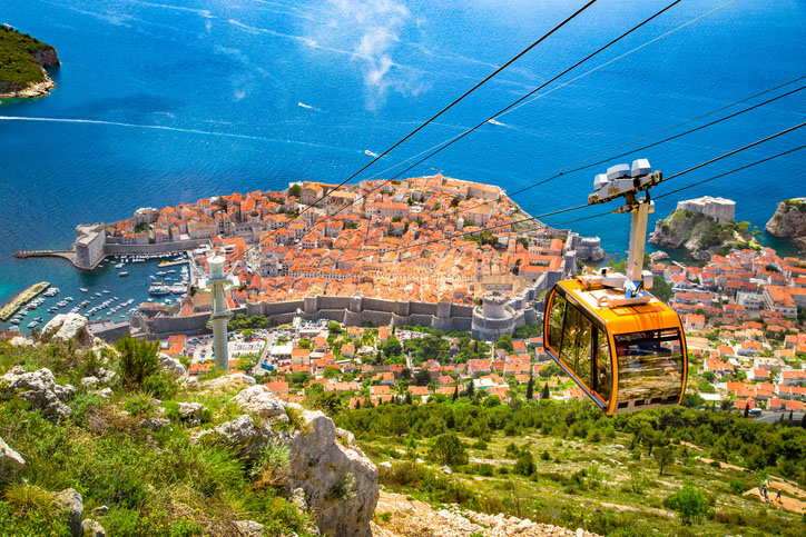 Old town of Dubrovnik with cable car ascending Srd mountain