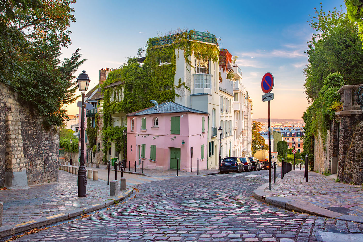 Cozy old street with pink house at the sunny sunrise in Paris, France