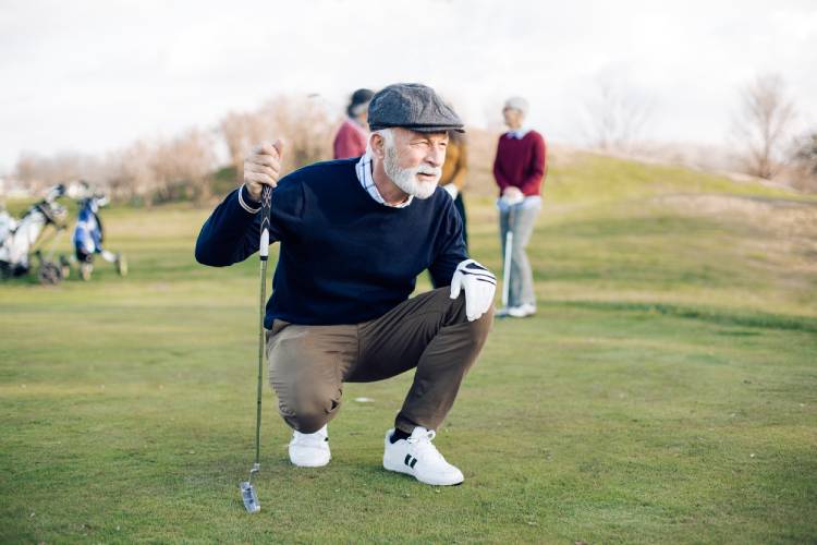 Senior man playing golf with his friends