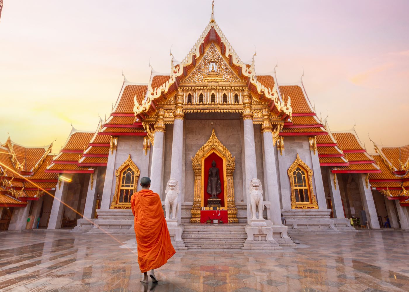 monk facing temple at sunset